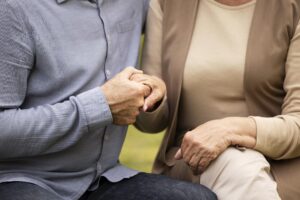close up of two people torsos, holding trusting hands